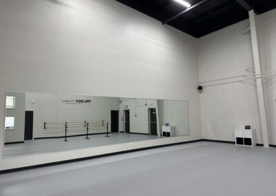 The dance practice hall at Trilogy Dance Academy, featuring spacious floors, mirrors, and a vibrant atmosphere for rehearsals and training.