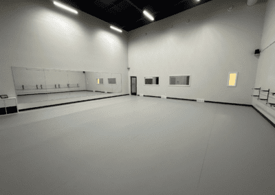 The dance practice hall at Trilogy Dance Academy, featuring spacious floors, mirrors, and a vibrant atmosphere for rehearsals and training.